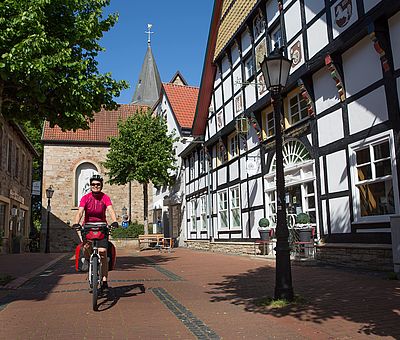 Eine Radfahrerin fährt durch den schönen Ortskern von Hagen a.T.W. 