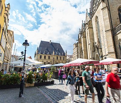 Das Rathaus des Westfälischen Friedens, Stadtwaage und Marienkirche auf der einen, typische Osnabrücker Bürgerhäuser mit ihren Treppengiebeln auf der anderen Seite umranden den historischen Platz.